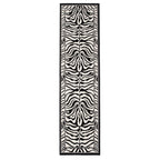 A long rectangular area rug with a bold black and off-white zebra stripe pattern, framed by a thin black border, shown against a plain white background.
