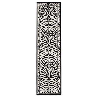 A long rectangular area rug with a bold black and off-white zebra stripe pattern, framed by a thin black border, shown against a plain white background.
