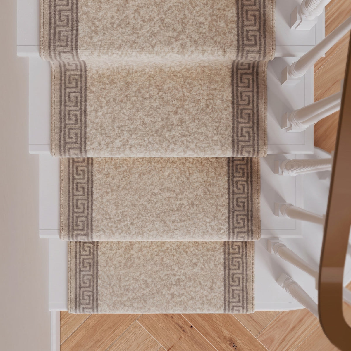Four carpet stair runners with a beige and brown damask pattern and Greek key borders, shown installed on a staircase with light wood flooring and white banister posts.