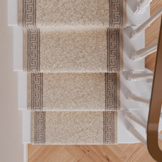Four carpet stair runners with a beige and brown damask pattern and Greek key borders, shown installed on a staircase with light wood flooring and white banister posts.