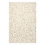 A rectangular high-pile shag rug in a warm cream or ivory color, shown from a top-down view on a plain white background.