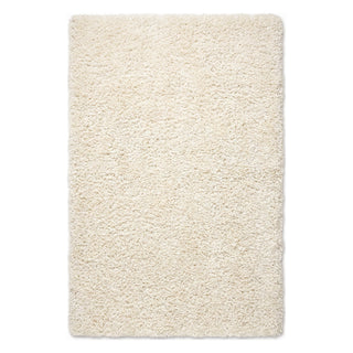 A rectangular high-pile shag rug in a warm cream or ivory color, shown from a top-down view on a plain white background.