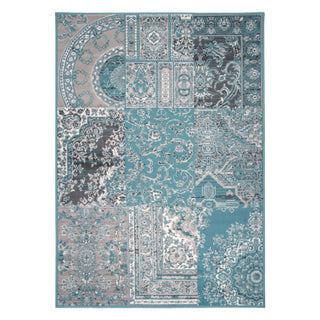 A rectangular area rug with a complex patchwork-style traditional pattern in shades of teal, blue, gray, beige, and white, shown flat against a plain white background.