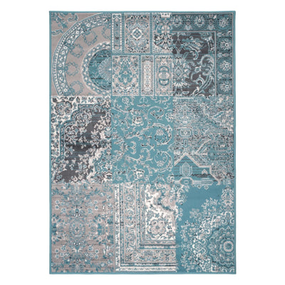 A rectangular area rug with a complex patchwork-style traditional pattern in shades of teal, blue, gray, beige, and white, shown flat against a plain white background.