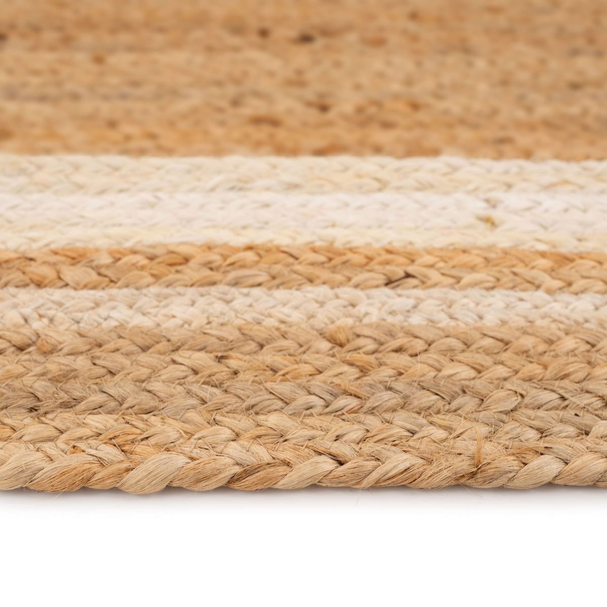 Close-up of a woven jute rug with beige and brown stripes on a white background