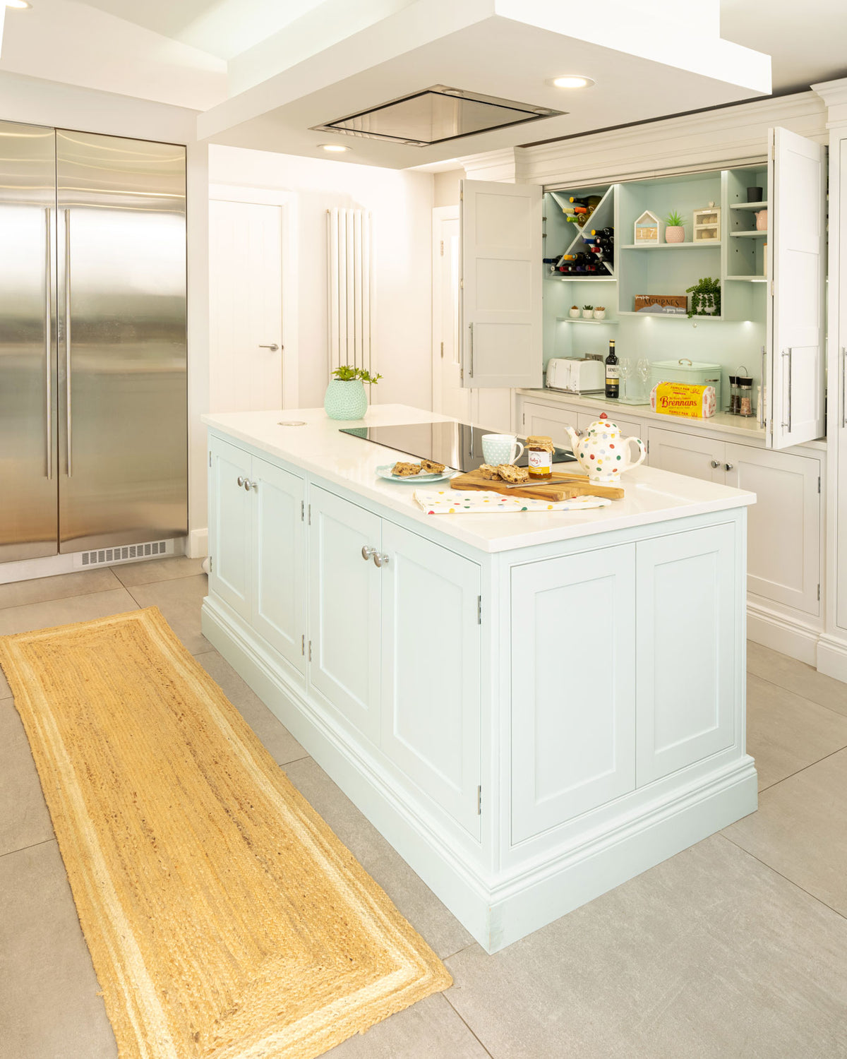 Modern kitchen with white cabinets, a island, and stainless steel appliances.