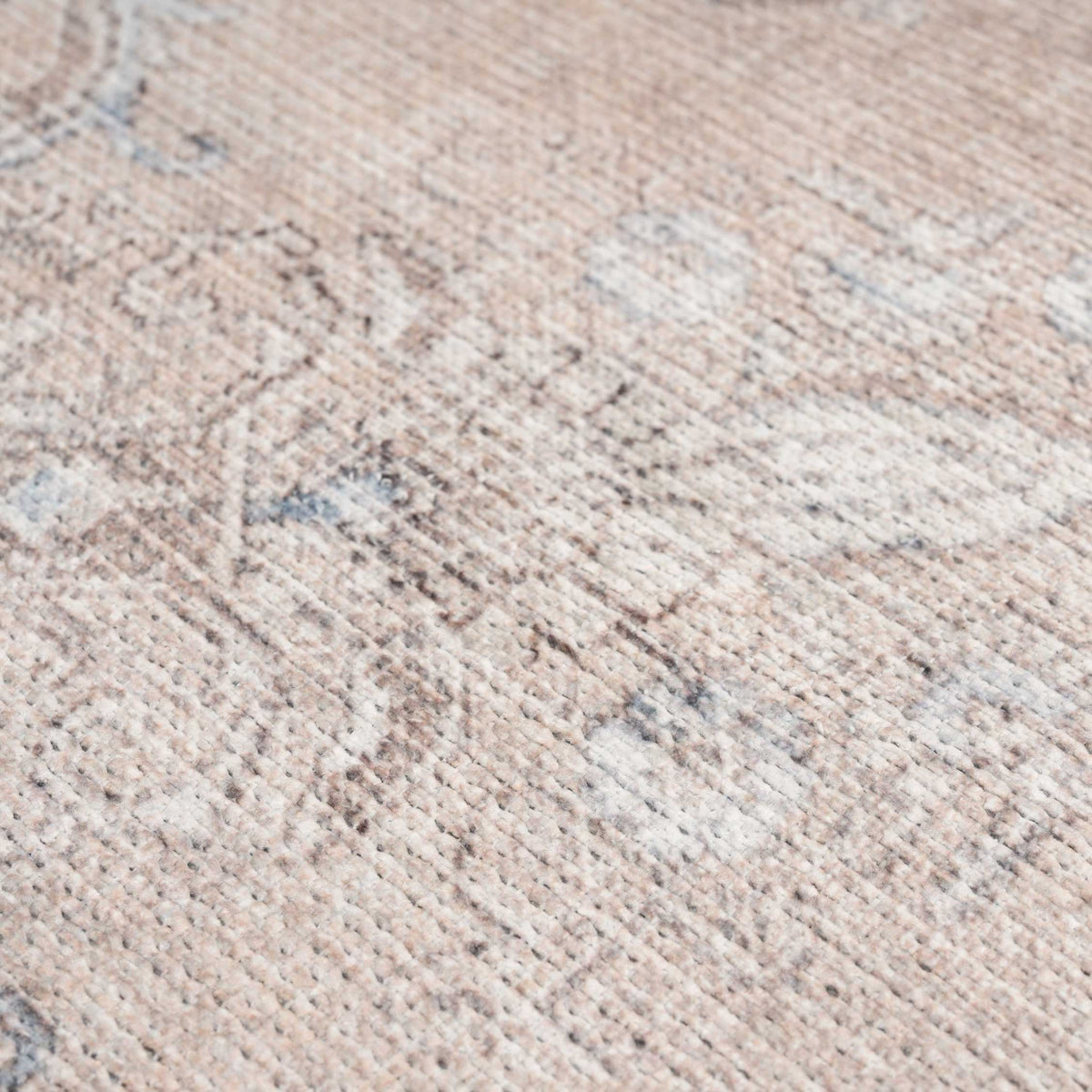 Close-up of a textured beige carpet with subtle patterns