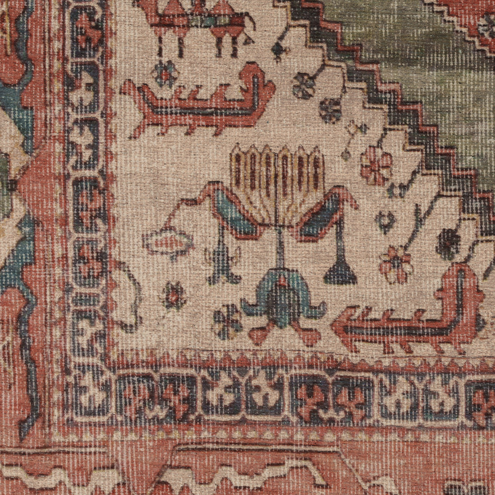 Close-up of an antique Persian-style rug showing detailed woven patterns, a central medallion, and traditional motifs in muted beige, terracotta, and navy blue.