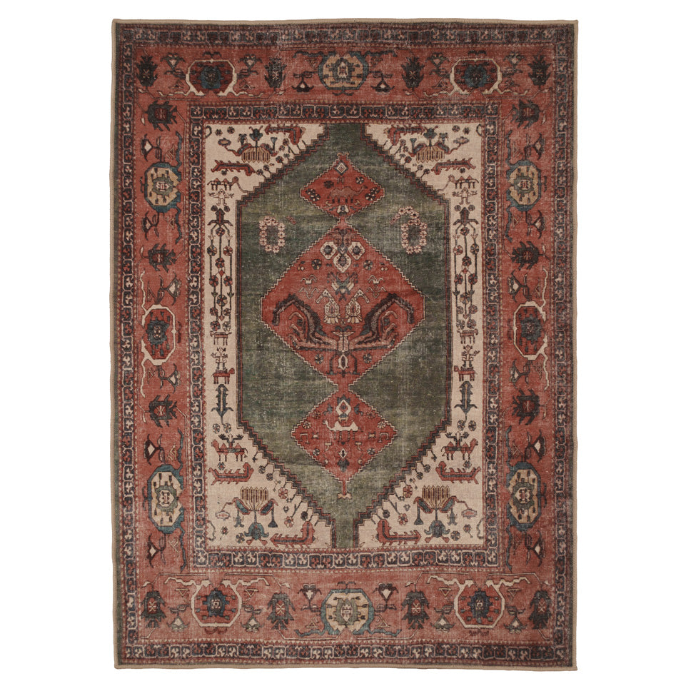A rectangular vintage-style area rug with a distressed tribal pattern, featuring a muted green central field, rust-red borders, and cream accents.