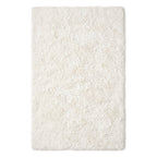 A rectangular shag rug in a warm off-white or cream color, shown from a top-down view against a plain white background.