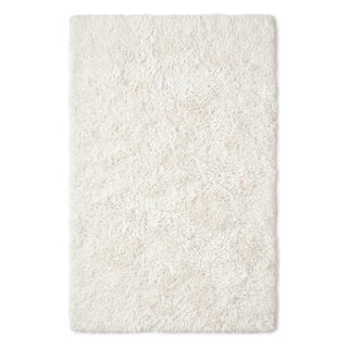 A rectangular shag rug in a warm off-white or cream color, shown from a top-down view against a plain white background.