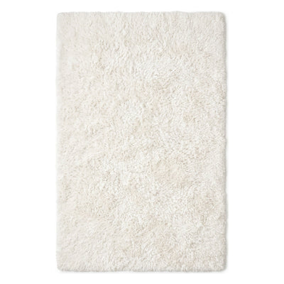 A rectangular shag rug in a warm off-white or cream color, shown from a top-down view against a plain white background.