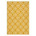 A rectangular area rug with a mustard yellow background and a white geometric trellis pattern, shown flat against a white background.