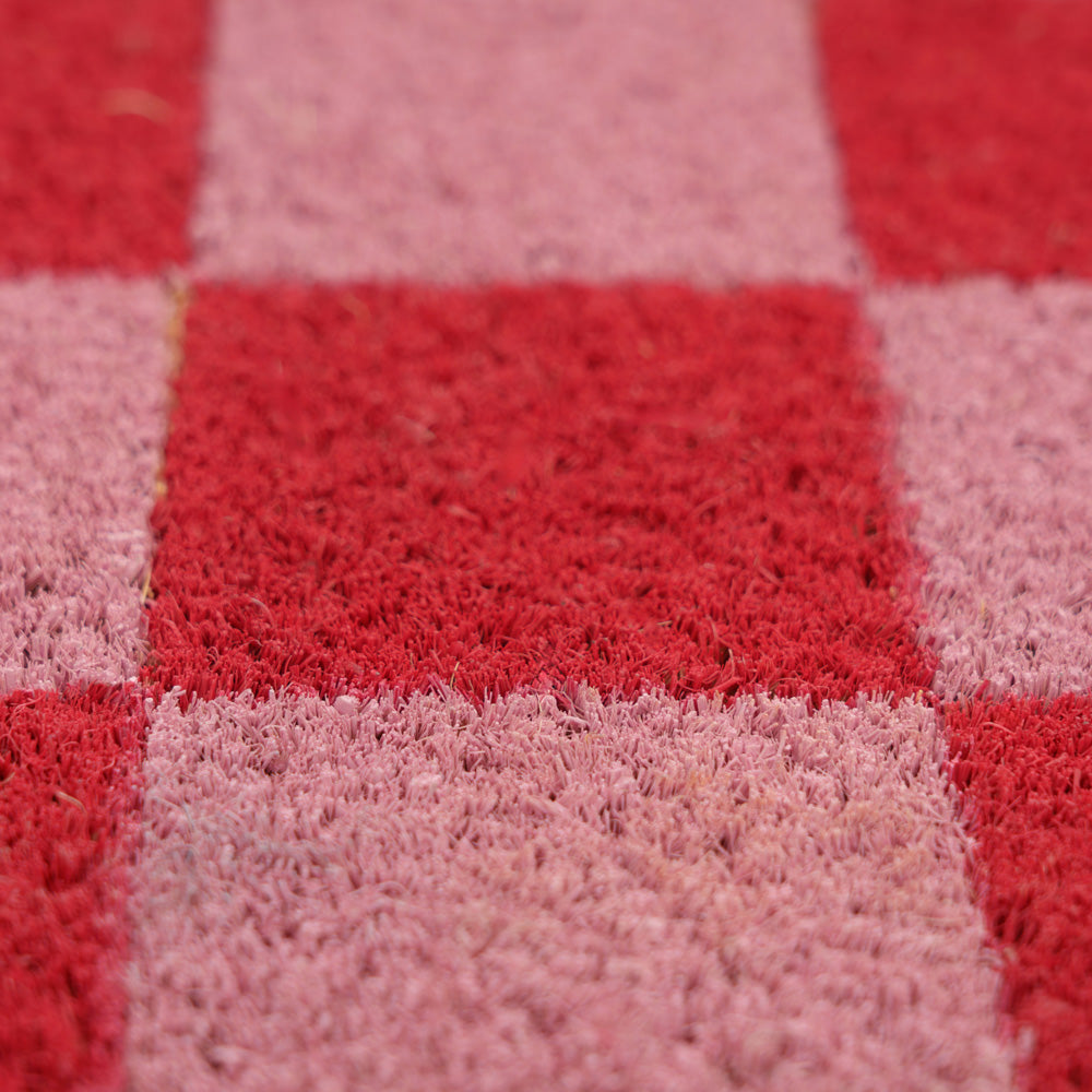 Close-up of a red and pink checkered doormat