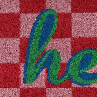 Textured surface with 'hello' in green and blue on a red and pink checkered background