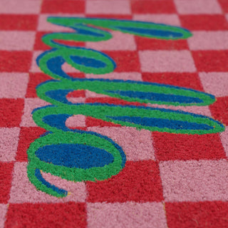 Checkered doormat with 'hello' in green and blue on a red and pink background