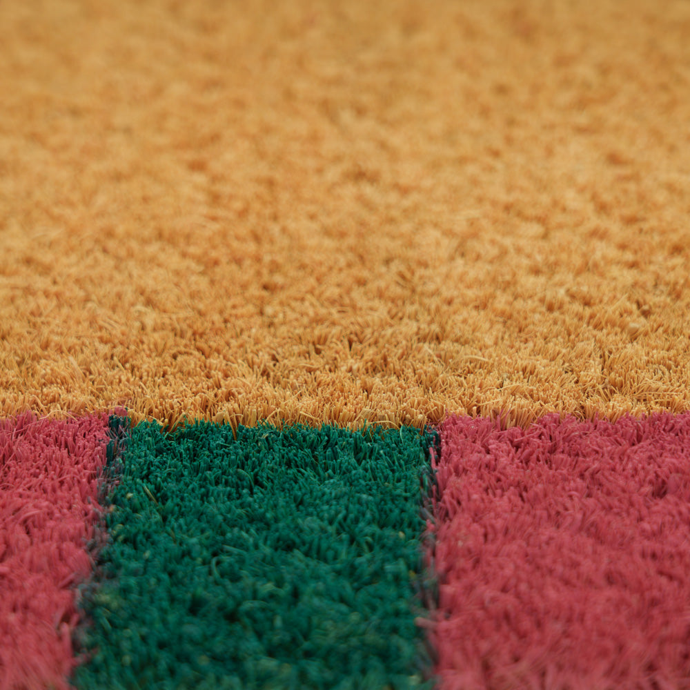 Close-up of a doormat with a multicolored pattern