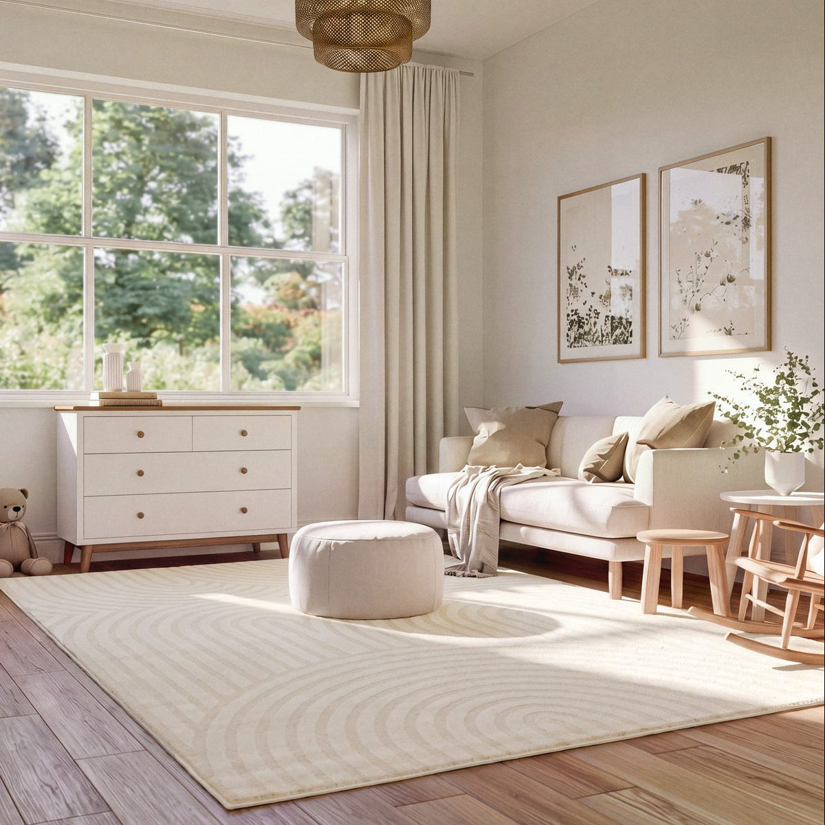 A large cream-colored area rug with a concentric wave pattern in a bright, modern living room. The room features a cream sofa, a matching ottoman, a white dresser, and light wood flooring.