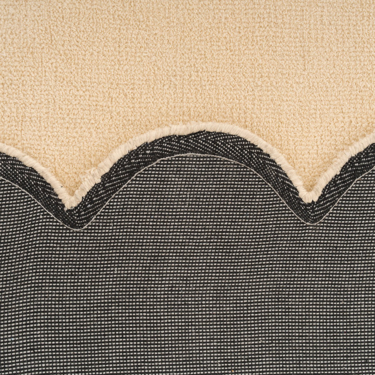 Close-up of a textured fabric with a wavy edge on a beige background