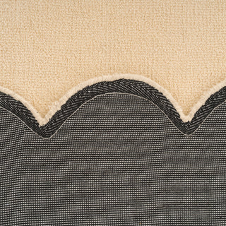 Close-up of a textured fabric with a wavy edge on a beige background