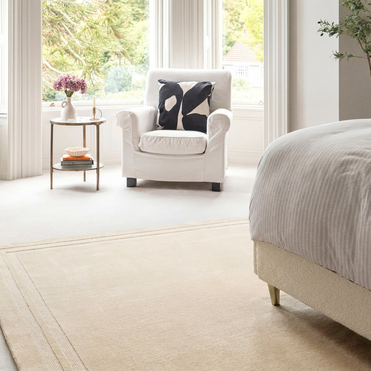 Modern bedroom with a bed, armchair, and side table.