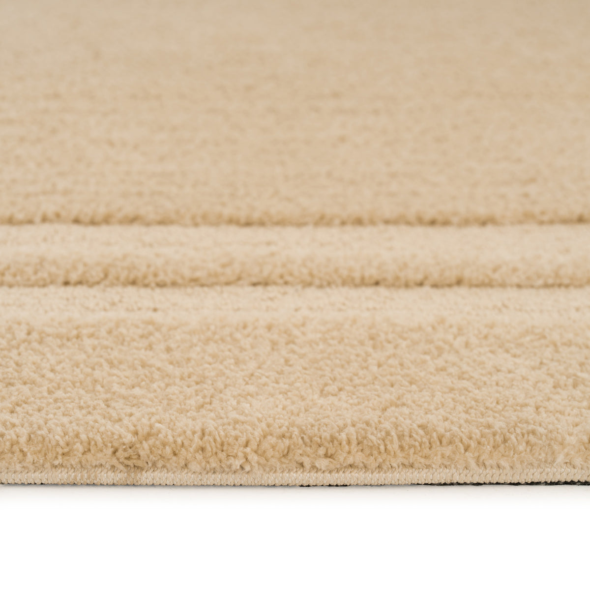 Close-up of a beige carpet with a soft texture on a white background
