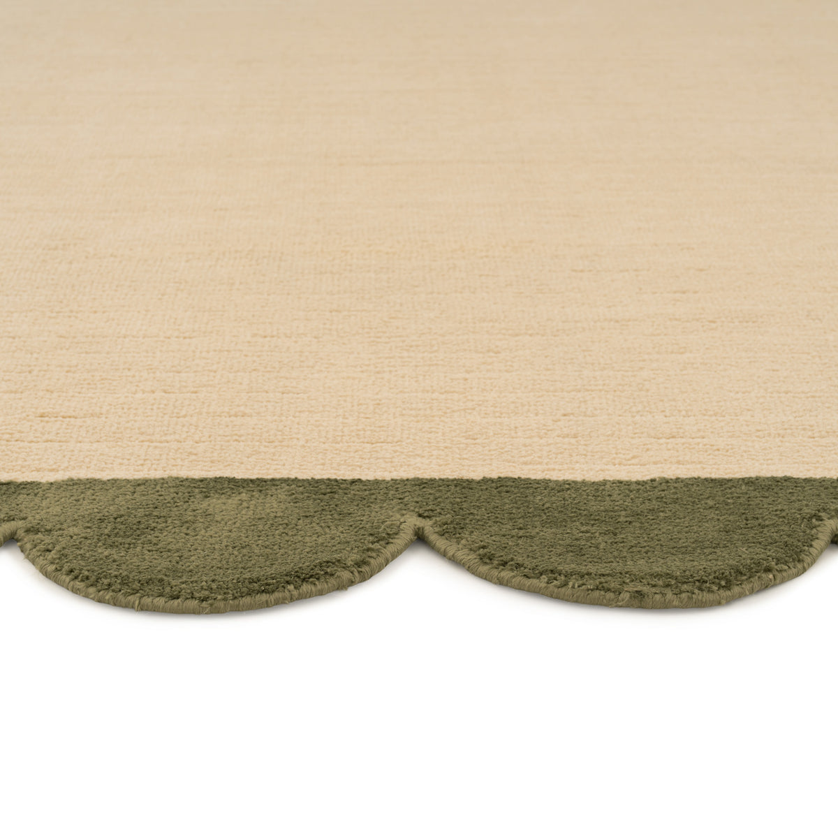 Textured beige and green rug with scalloped edge