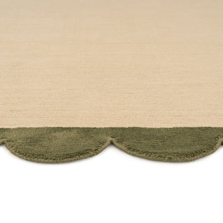 Textured beige and green rug with scalloped edge
