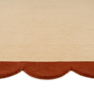 Beige fabric with a scalloped brown edge on a beige background
